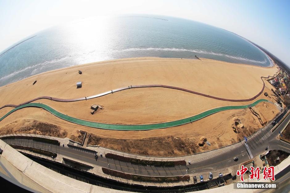 3月13日，秦皇島萬米臨海沙灘木棧道。據(jù)了解，該木棧道全長約4200米，與北戴河區(qū)原有的7500米木棧道對接后全線總長度1.17萬米，整個木棧道東起秦皇島體育基地游船碼頭，西至北戴河濕地公園，呈波浪形蜿蜒10.4公里海岸線。 中新社發(fā) 曹建雄 攝 CNSPHOTO